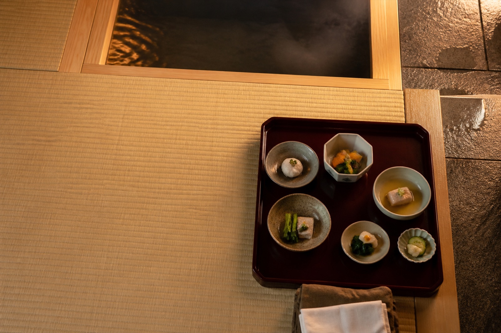 Japansk flerrättersmiddag på ryokan med små skålar på en låg lackad bricka